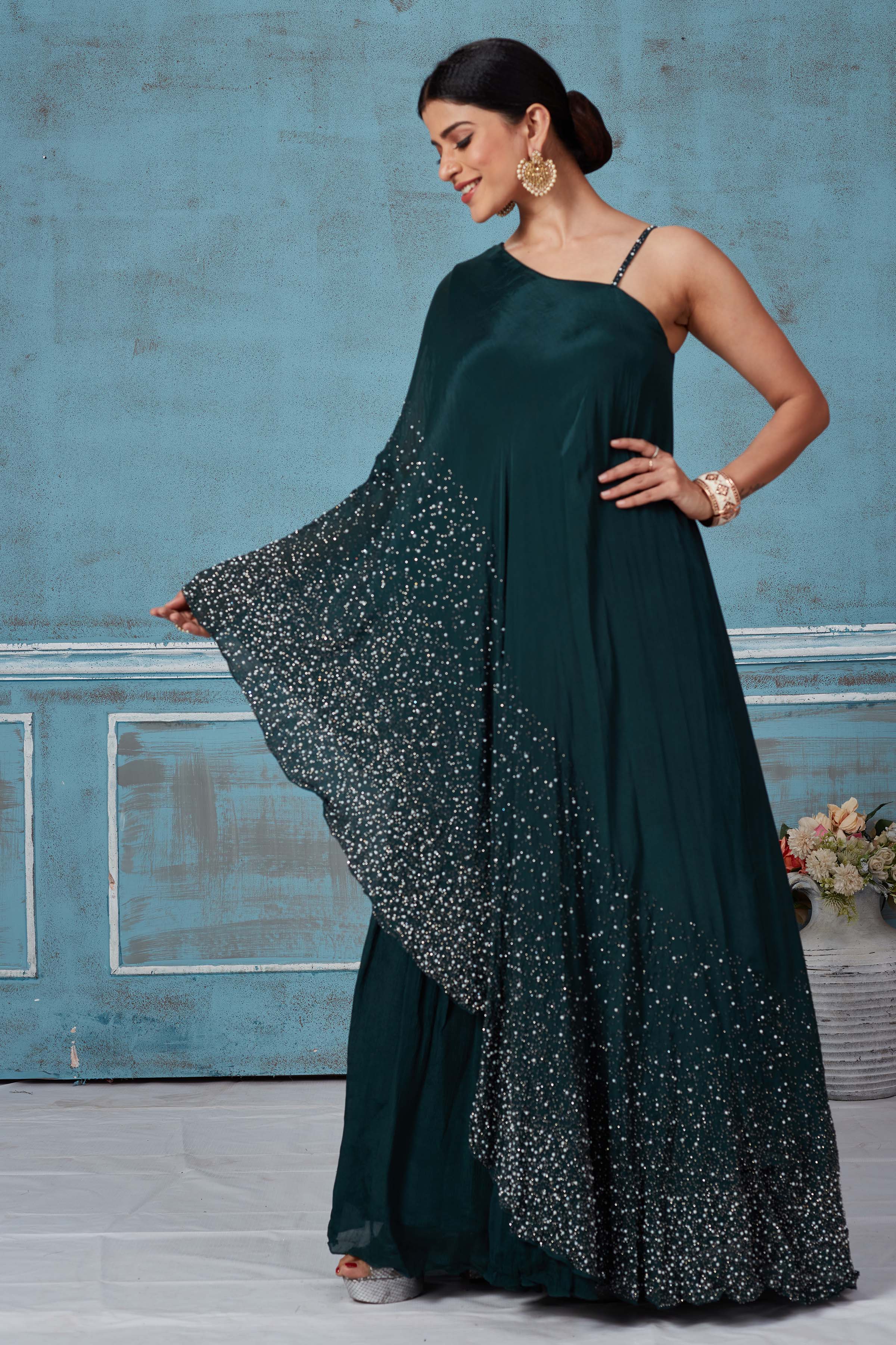 Shop dark green one shoulder georgette dress online in USA. Look royal on special occasions in exquisite designer lehengas, pure silk sarees, handloom sarees, Bollywood sarees, Anarkali suits, Banarasi sarees, organza sarees from Pure Elegance Indian saree store in USA.-front