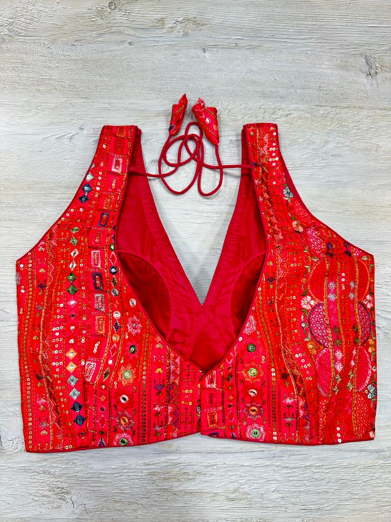 Buy red multicolor sleeveless blouse with thread and mirror embroidery. Make a fashion statement on festive occasions and weddings with designer blouses, designer sarees, designer suits, Indian dresses, designer gowns, sharara suits, and embroidered sarees from Pure Elegance Indian fashion store in the USA.