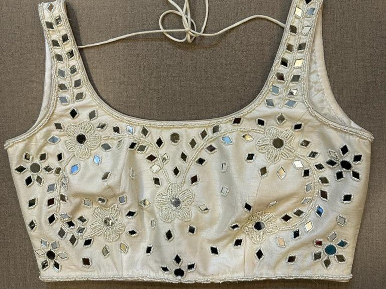 Buy White sleeveless blouse with mirror work Make a fashion statement on festive occasions and weddings with designer blouses, designer sarees, designer suits, Indian dresses, designer gowns, sharara suits, and embroidered sarees from Pure Elegance Indian fashion store in the USA.