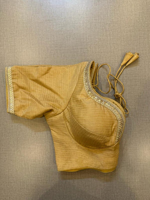 Buy beige silk blouse with embroidery on the edge, hook closure & tie-back at the back.. Make a fashion statement on festive occasions and weddings with designer blouses, designer sarees, designer suits, Indian dresses, designer gowns, sharara suits, and embroidered sarees from Pure Elegance Indian fashion store in the USA.