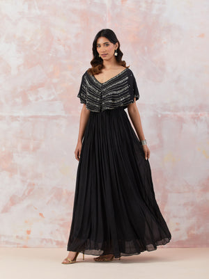 Buy Black caped gown featuring intricate handwork and immaculate detailing. It is best suited for occasions & parties. Dazzle on weddings and special occasions with exquisite Indian designer dresses, sharara suits, Anarkali suits, and wedding lehengas from Pure Elegance Indian fashion store in the USA.