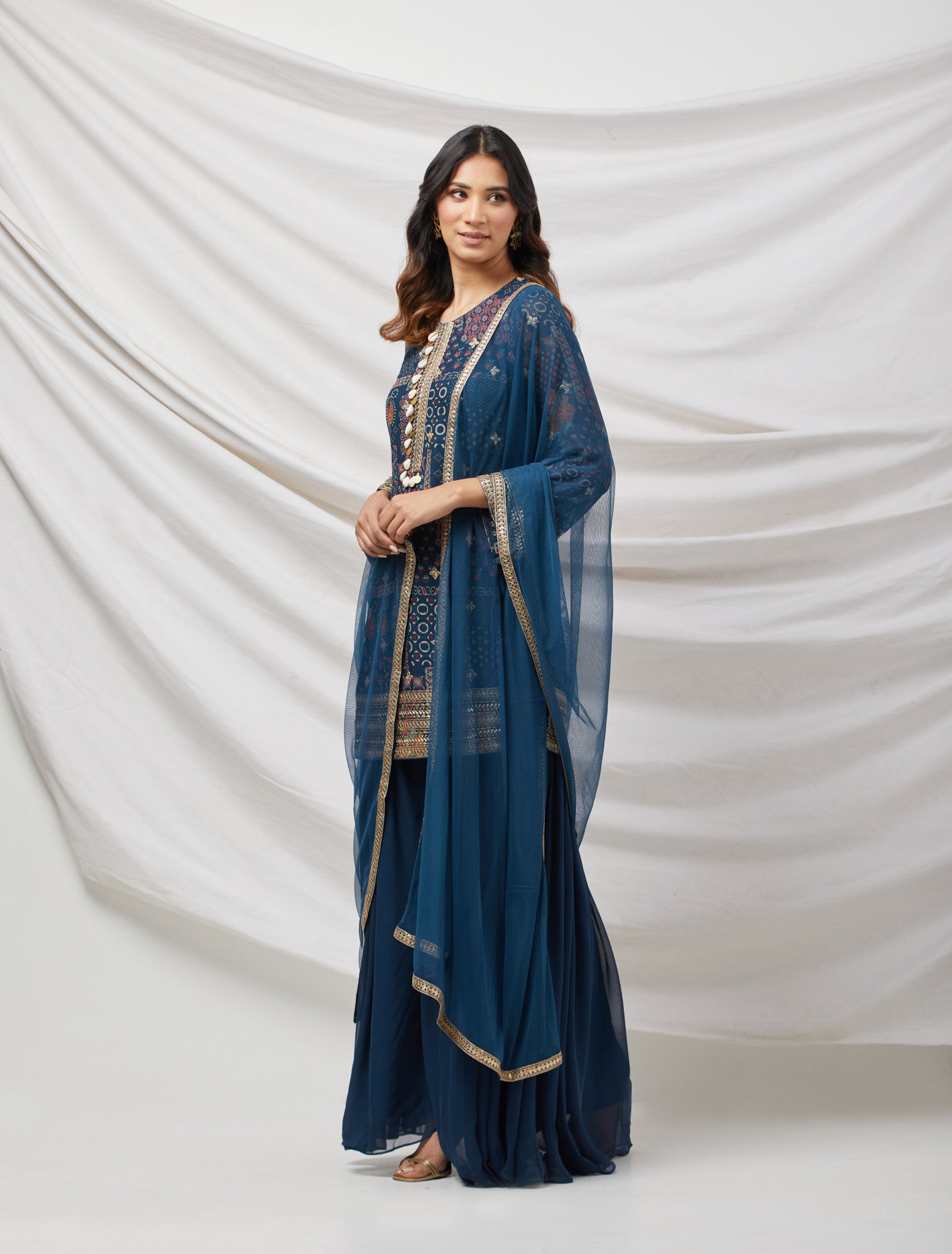 Buy teal blue sharara set featuring Kurta with foil work, shells, and coin detailing, also plain sharara  It is best for occasions & parties. Dazzle on weddings and special occasions with exquisite Indian designer dresses, sharara suits, Anarkali suits, and wedding lehengas from Pure Elegance Indian fashion store in the USA.