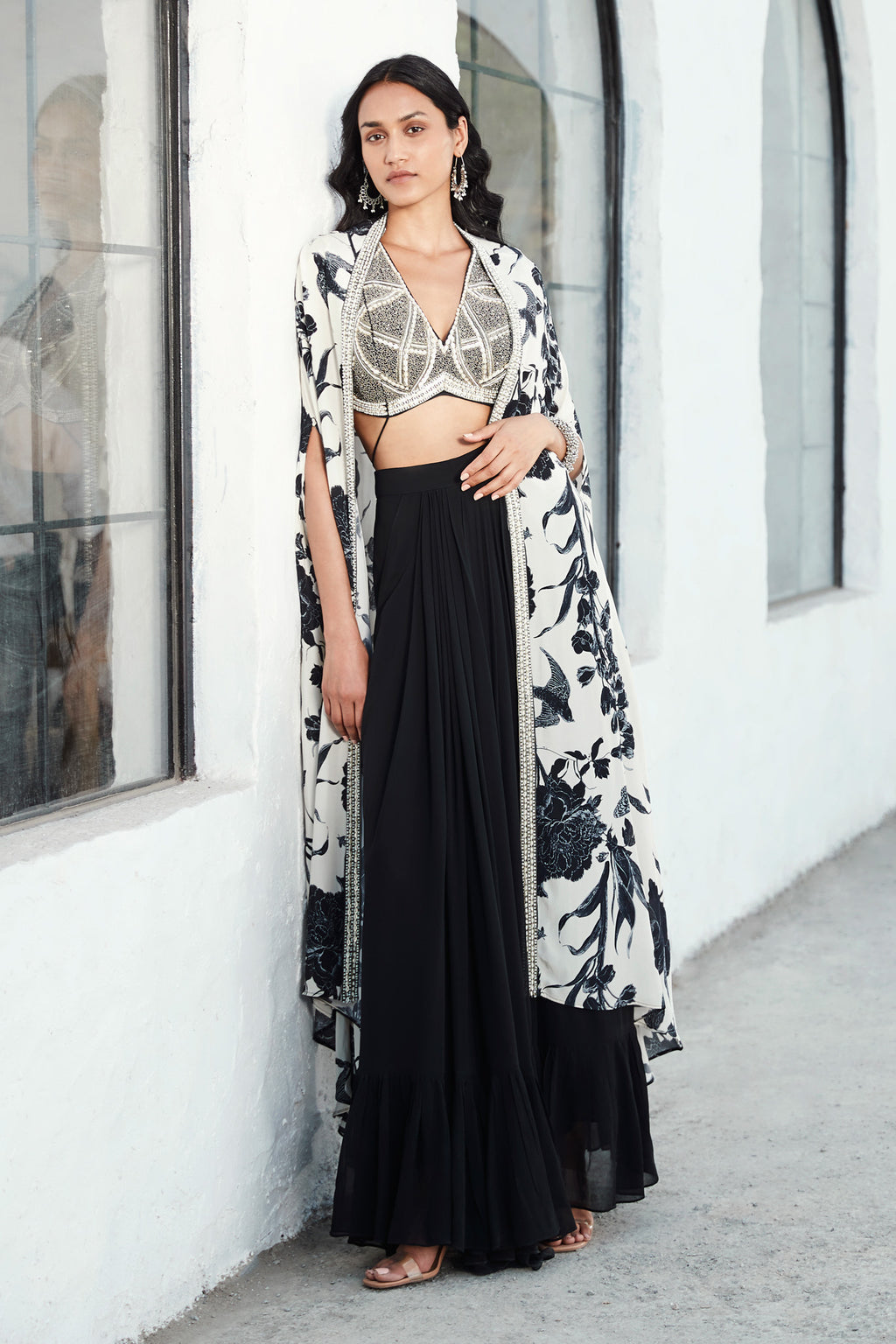 Buy black & white crepe sharara set adorned hand-embroidered viscose silk blouse & cape. Dazzle on weddings and special occasions with exquisite Indian designer dresses, sharara suits, Anarkali suits, and wedding lehengas from Pure Elegance Indian fashion store in the USA.