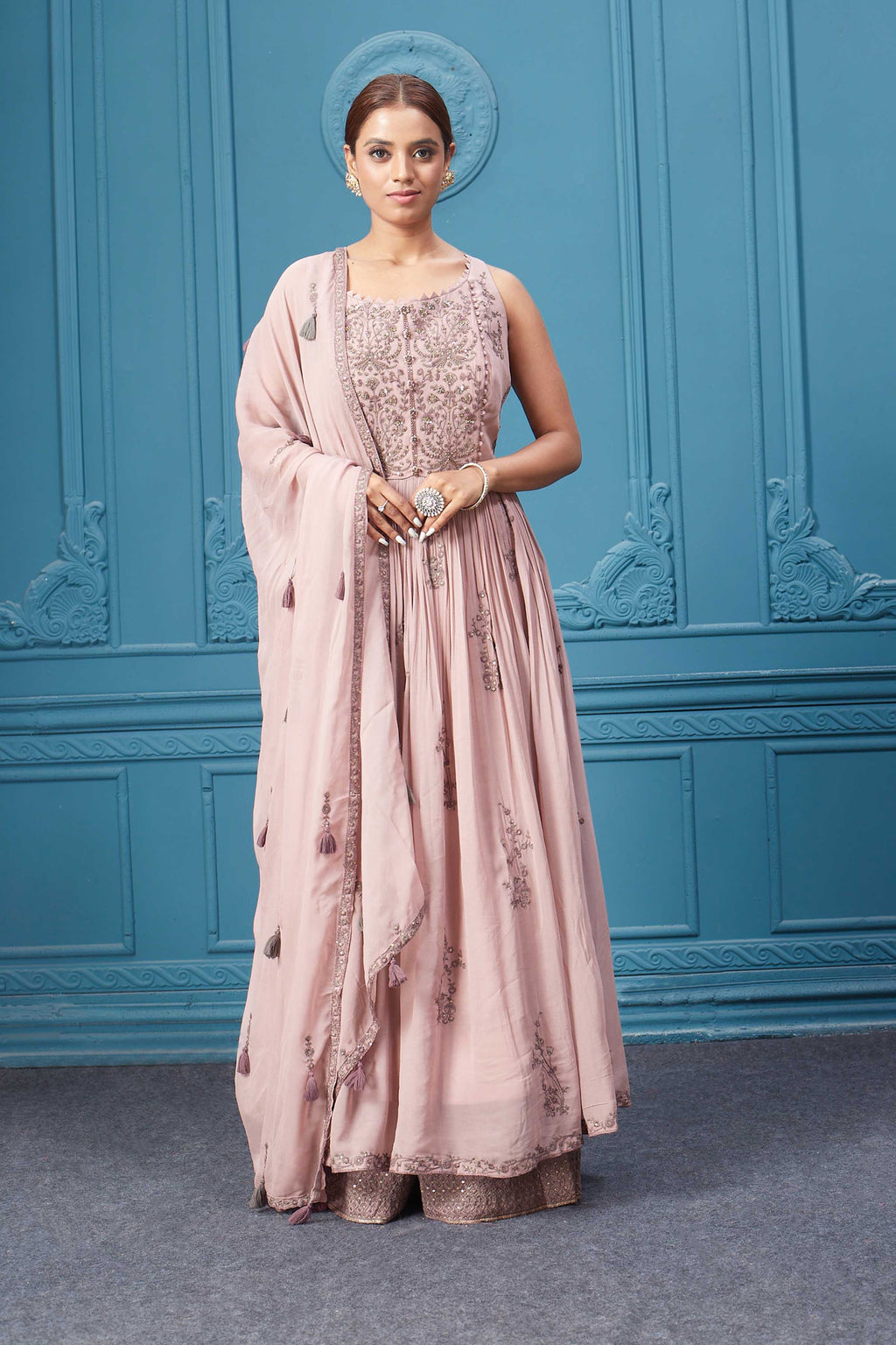 Shop a light pink embroidered sleeveless Anarkali kurta featuring mirror embroidery, embroidered bordered plazzo, and tassel work dupatta. Dazzle on special occasions with exquisite Indian designer dresses, sharara suits, Anarkali suits, bridal lehengas, and sharara suits from Pure Elegance Indian clothing store in the USA. Shop online from Pure Elegance.