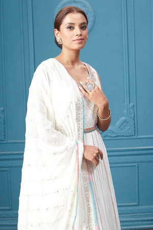 Buy a white embroidered sleeveless Anarkali kurta featuring mirror embroidery, embroidered borders, and a dupatta. Dazzle on special occasions with exquisite Indian designer dresses, sharara suits, Anarkali suits, bridal lehengas, and sharara suits from Pure Elegance Indian clothing store in the USA. Shop online from Pure Elegance.