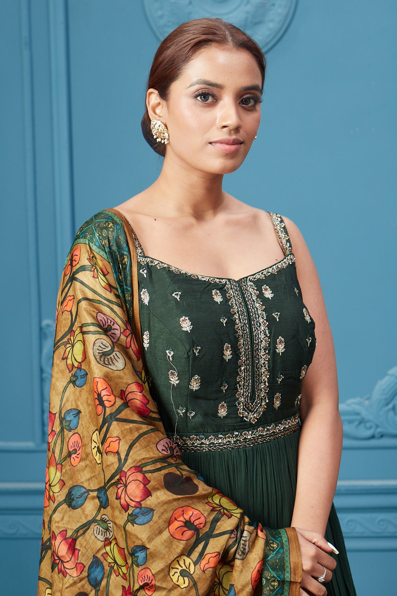 Shop a dark green embroidered sleeveless Anarkali suit with a floral mustard dupatta. Dazzle on special occasions with exquisite Indian designer dresses, sharara suits, Anarkali suits, bridal lehengas, and sharara suits from Pure Elegance Indian clothing store in the USA. Shop online from Pure Elegance.
