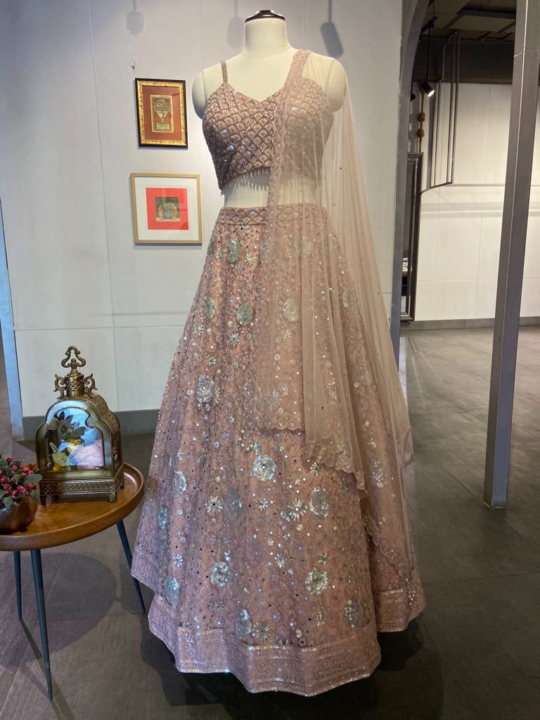 Shop peach embroidered net designer lehenga online in USA with dupatta. Look your best on festive occasions in latest designer saris, pure silk saris, Kanchipuram silk sarees, handwoven saris, tussar silk saris, designer suits, lehengas from Pure Elegance Indian clothing store in USA.-full view