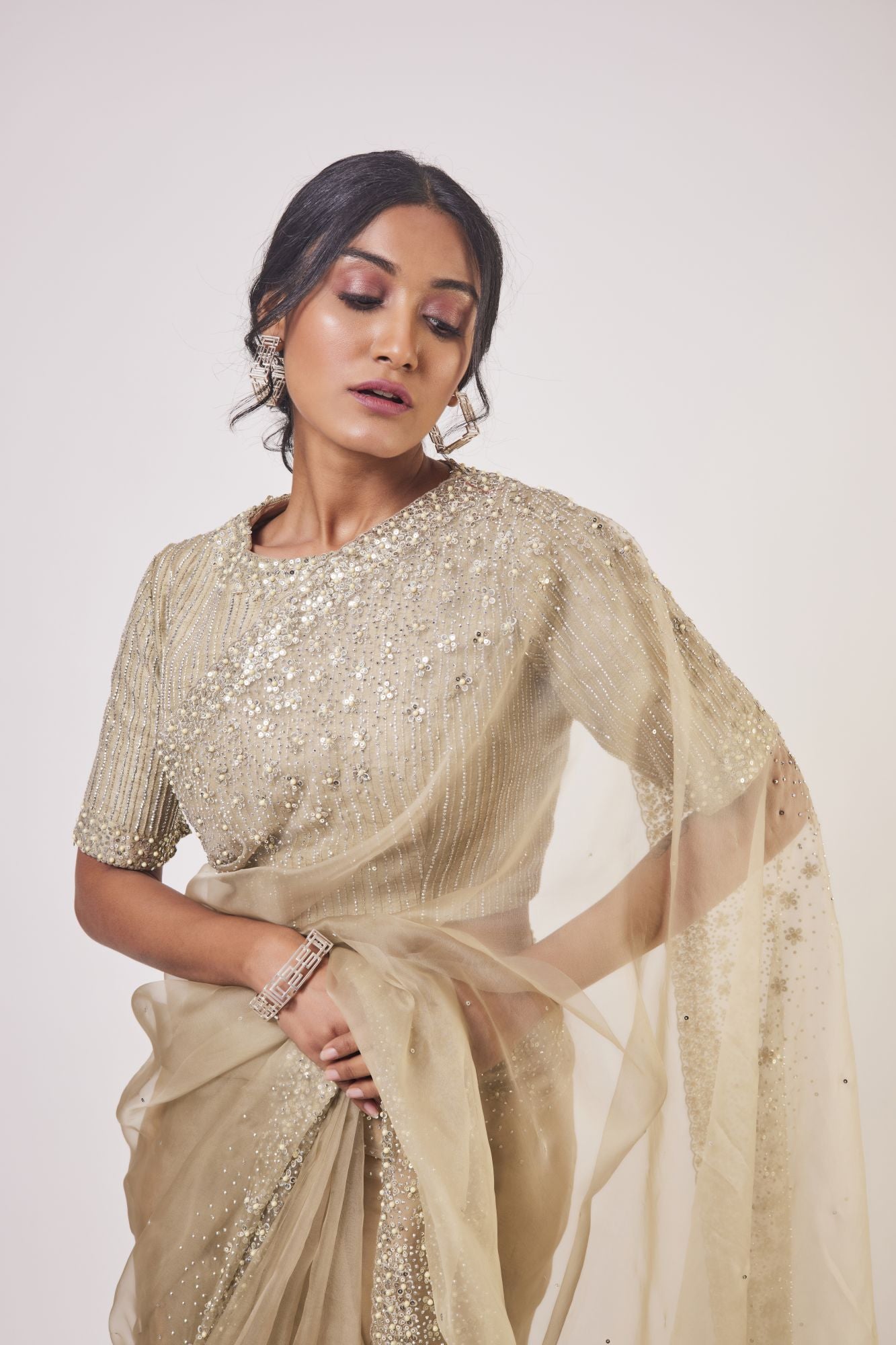 Shop beige organza saree online in USA with stone, cutdana and pearl work. Look your best at parties and weddings in beautiful designer sarees, embroidered sarees, handwoven sarees, silk sarees, organza saris from Pure Elegance Indian saree store in USA.-closeup