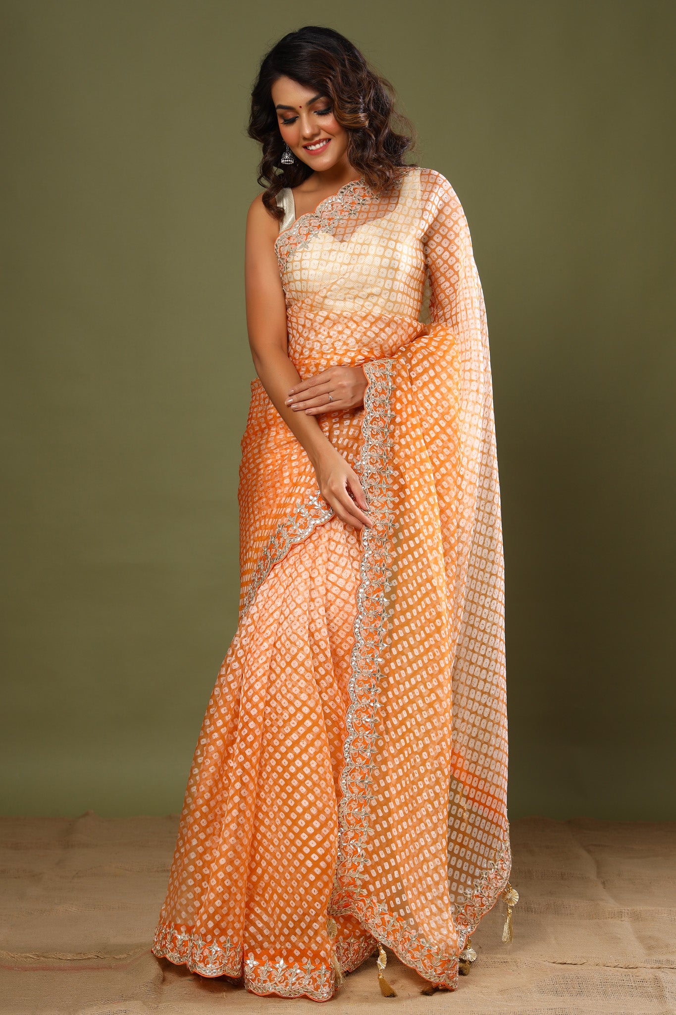 Buy beautiful light orange bandhej embroidered organza sari online in USA. Make a fashion statement at weddings with stunning designer sarees, embroidered sarees with blouse, wedding sarees, handloom sarees from Pure Elegance Indian fashion store in USA.-front