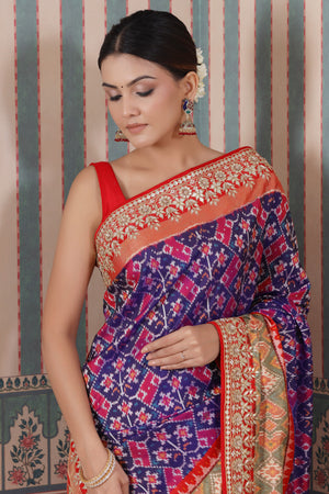 Buy purple Patola silk sari online in USA with red embroidered border. Make a fashion statement at weddings with stunning designer sarees, embroidered sarees with blouse, wedding sarees, handloom sarees from Pure Elegance Indian fashion store in USA.-closeup