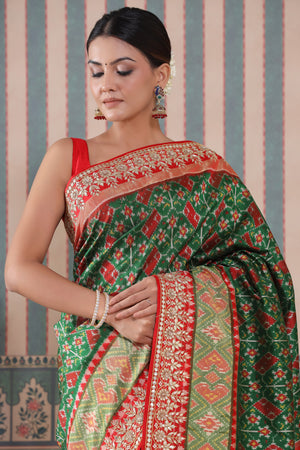 Shop green Patola silk sari online in USA with red embroidered border. Make a fashion statement at weddings with stunning designer sarees, embroidered sarees with blouse, wedding sarees, handloom sarees from Pure Elegance Indian fashion store in USA.-details