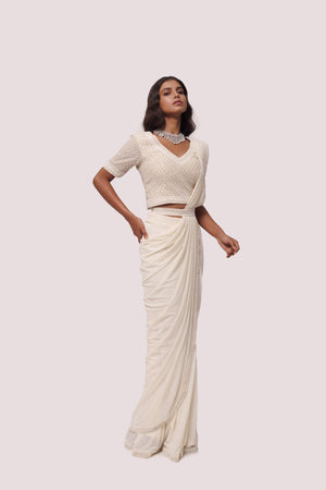 Shop off white drape saree with silver moti work. Make a fashion statement on festive occasions and weddings with designer sarees, designer suits, Indian dresses, Anarkali suits, palazzo suits, designer gowns, sharara suits, and embroidered sarees from Pure Elegance Indian fashion store in the USA.