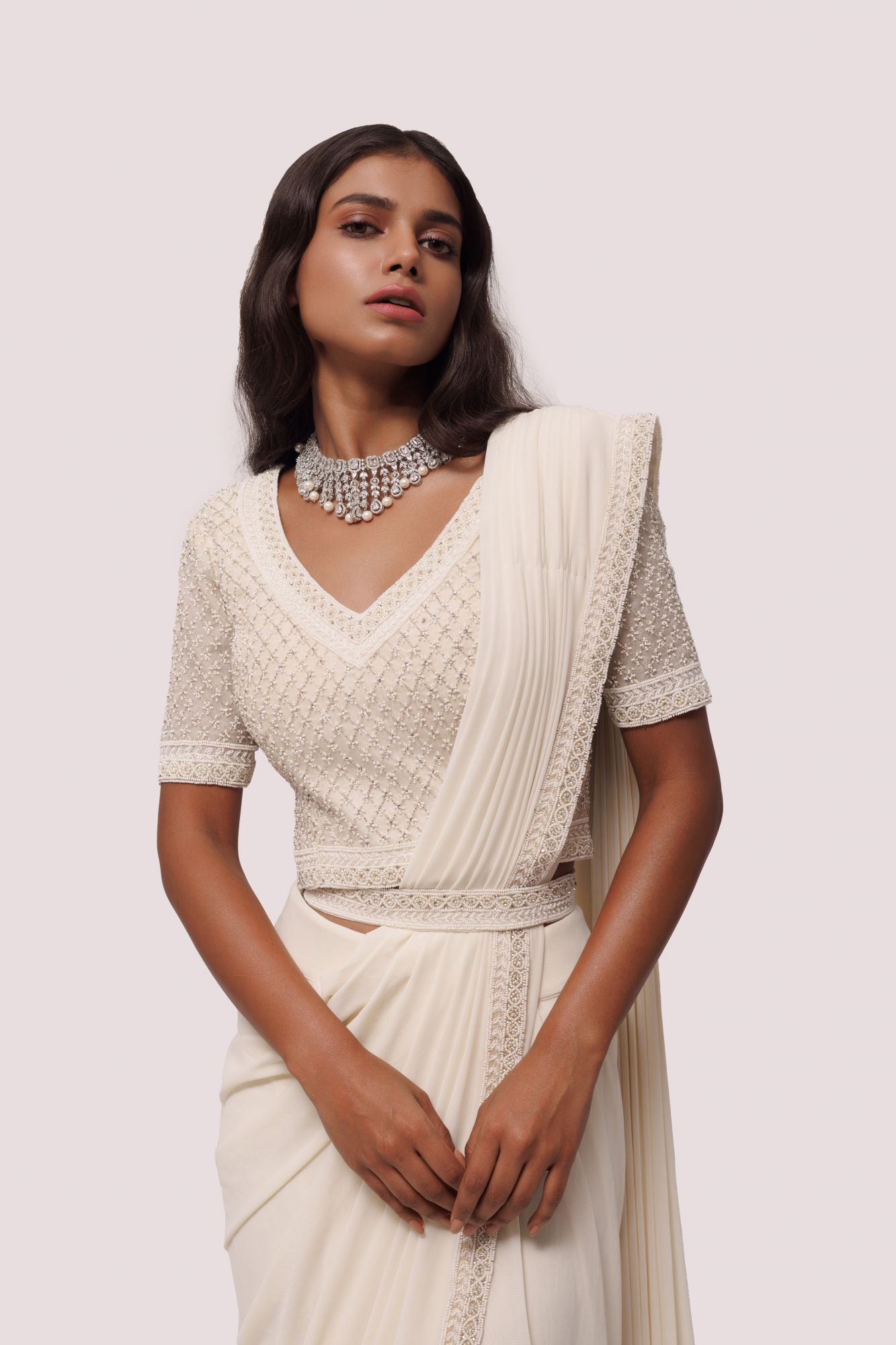 Shop off white drape saree with silver moti work. Make a fashion statement on festive occasions and weddings with designer sarees, designer suits, Indian dresses, Anarkali suits, palazzo suits, designer gowns, sharara suits, and embroidered sarees from Pure Elegance Indian fashion store in the USA.