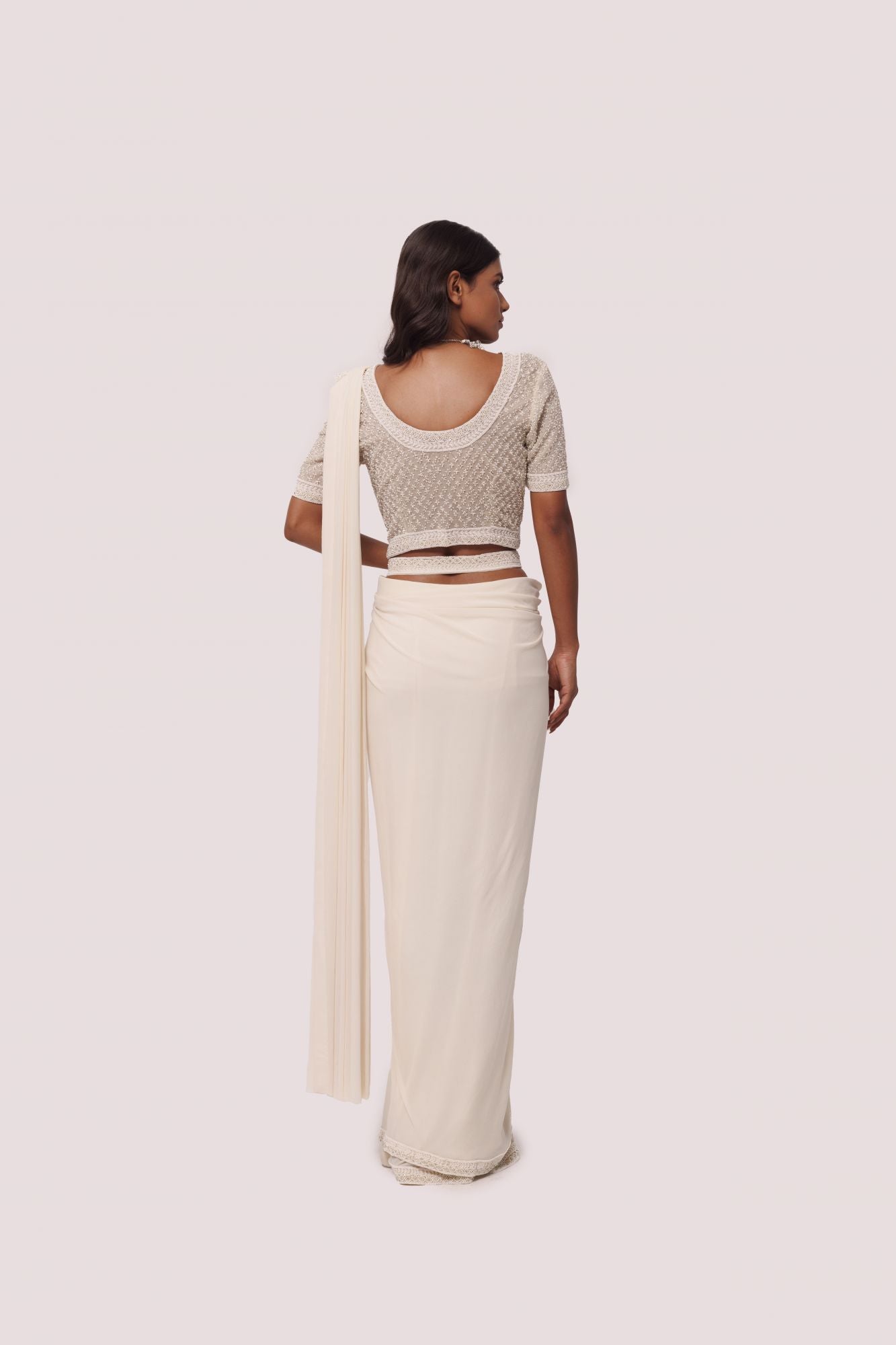 Shop off white drape saree with silver moti work. Make a fashion statement on festive occasions and weddings with designer sarees, designer suits, Indian dresses, Anarkali suits, palazzo suits, designer gowns, sharara suits, and embroidered sarees from Pure Elegance Indian fashion store in the USA.