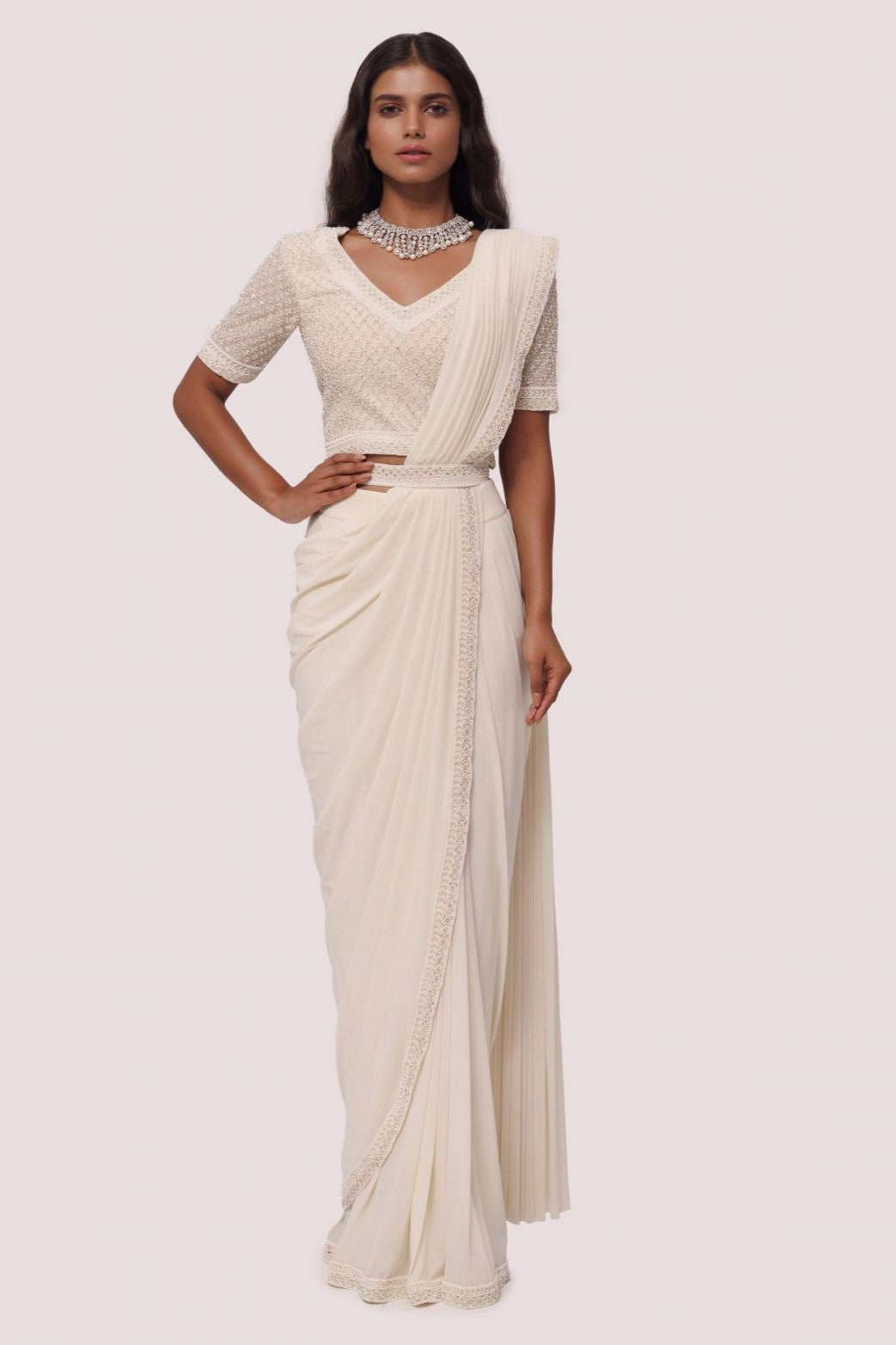 Shop off white drape saree with silver moti work. Make a fashion statement on festive occasions and weddings with designer sarees, designer suits, Indian dresses, Anarkali suits, palazzo suits, designer gowns, sharara suits, and embroidered sarees from Pure Elegance Indian fashion store in the USA.