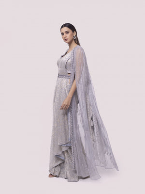 Shop silver organza drape saree with a net cape. Make a fashion statement on festive occasions and weddings with designer sarees, designer suits, Indian dresses, Anarkali suits, palazzo suits, designer gowns, sharara suits, and embroidered sarees from Pure Elegance Indian fashion store in the USA.