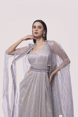 Shop silver organza drape saree with a net cape. Make a fashion statement on festive occasions and weddings with designer sarees, designer suits, Indian dresses, Anarkali suits, palazzo suits, designer gowns, sharara suits, and embroidered sarees from Pure Elegance Indian fashion store in the USA.