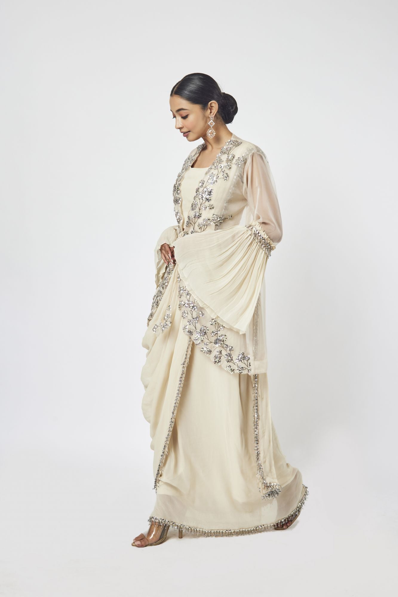 Shop offwhite drape saree with ruffle sleeves Make a fashion statement on festive occasions and weddings with designer sarees, designer suits, Indian dresses, Anarkali suits, palazzo suits, designer gowns, sharara suits, and embroidered sarees from Pure Elegance Indian fashion store in the USA.