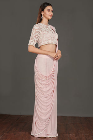 Shop pink satin drape with a designer white laced blouse. Make a fashion statement on festive occasions and weddings with designer sarees, designer suits, Indian dresses, Anarkali suits, palazzo suits, designer gowns, sharara suits, and embroidered sarees from Pure Elegance Indian fashion store in the USA.