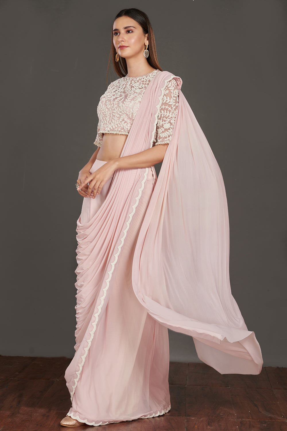 Shop pink satin drape with a designer white laced blouse. Make a fashion statement on festive occasions and weddings with designer sarees, designer suits, Indian dresses, Anarkali suits, palazzo suits, designer gowns, sharara suits, and embroidered sarees from Pure Elegance Indian fashion store in the USA.