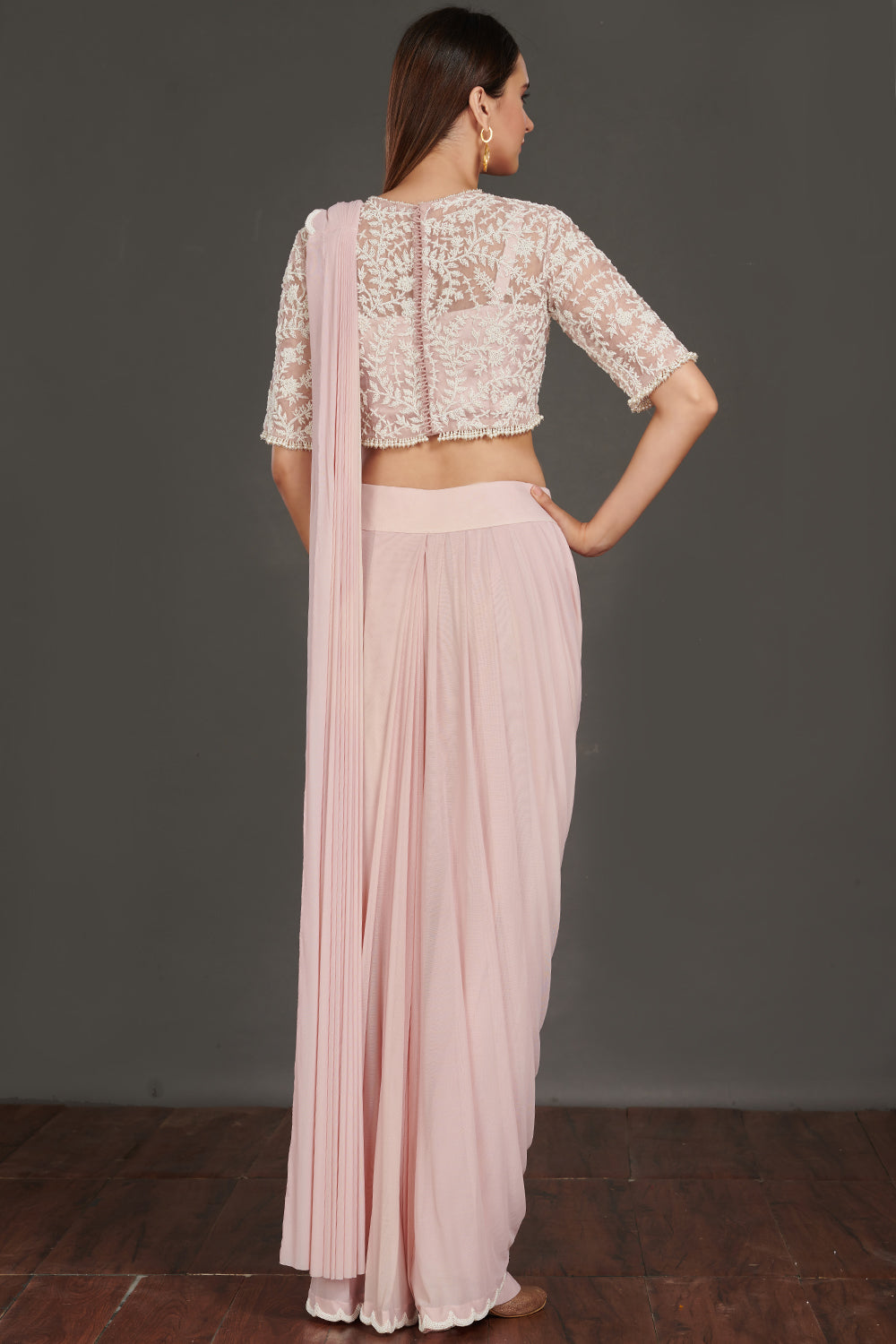 Shop pink satin drape with a designer white laced blouse. Make a fashion statement on festive occasions and weddings with designer sarees, designer suits, Indian dresses, Anarkali suits, palazzo suits, designer gowns, sharara suits, and embroidered sarees from Pure Elegance Indian fashion store in the USA.