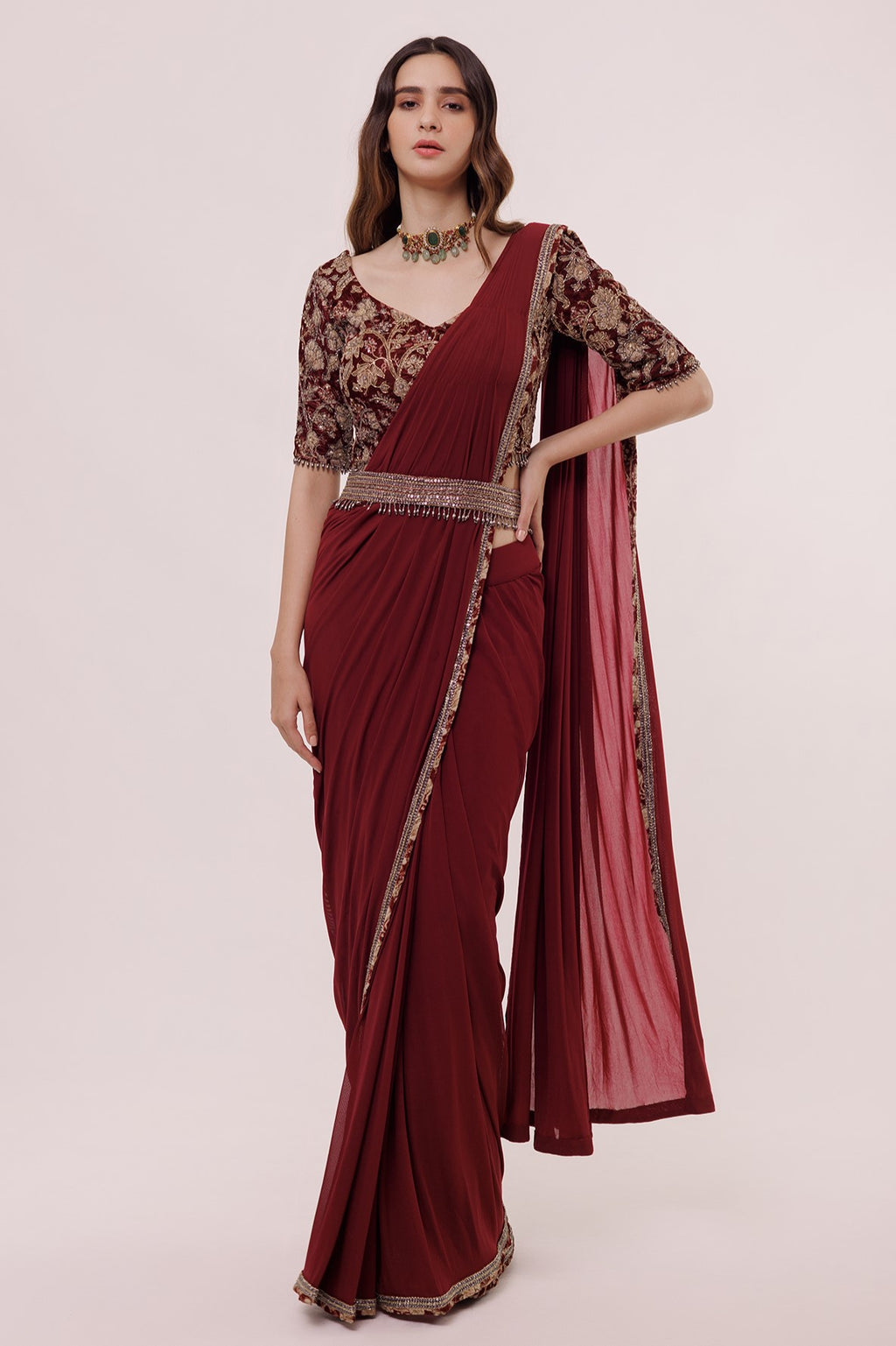 Shop wine net saree with embroidered edges and a narrow belt. Make a fashion statement on festive occasions and weddings with designer sarees, designer suits, Indian dresses, Anarkali suits, palazzo suits, designer gowns, sharara suits, and embroidered sarees from Pure Elegance Indian fashion store in the USA.