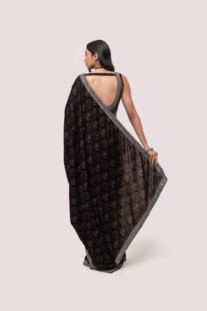 Shop a Beautiful mehndi green velvet saree featuring dark-toned motifs embellished edges and cheed, sequin work. It comes with a highly decorative blouse. Make a fashion statement on festive occasions and weddings with designer sarees, designer suits, Indian dresses, Anarkali suits, palazzo suits, designer gowns, sharara suits, and embroidered sarees from Pure Elegance Indian fashion store in the USA.