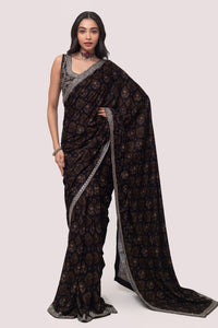 Shop a Beautiful mehndi green velvet saree featuring dark-toned motifs embellished edges and cheed, sequin work. It comes with a highly decorative blouse. Make a fashion statement on festive occasions and weddings with designer sarees, designer suits, Indian dresses, Anarkali suits, palazzo suits, designer gowns, sharara suits, and embroidered sarees from Pure Elegance Indian fashion store in the USA.- Full View