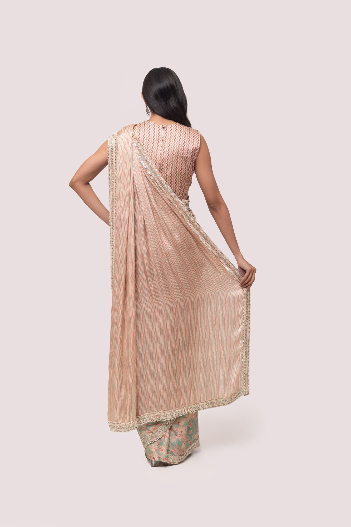 Shop a beautiful multicolored floral saree featuring sequin and cheed work. It comes with a heavily embroidered full-back sleeveless blouse.  Make a fashion statement on festive occasions and weddings with designer sarees, designer suits, Indian dresses, Anarkali suits, palazzo suits, designer gowns, sharara suits, and embroidered sarees from Pure Elegance Indian fashion store in the USA.