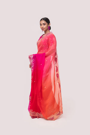 Shop a pink organza saree featuring zari embroidered edges. Make a fashion statement on festive occasions and weddings with designer sarees, designer suits, Indian dresses, Anarkali suits, palazzo suits, designer gowns, sharara suits, and embroidered sarees from Pure Elegance Indian fashion store in the USA.