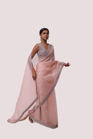 Shop peach organza saree with embellishments featuring cut dana work. Make a fashion statement on festive occasions and weddings with designer sarees, designer suits, Indian dresses, Anarkali suits, palazzo suits, designer gowns, sharara suits, and embroidered sarees from Pure Elegance Indian fashion store in the USA.