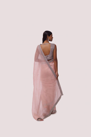 Shop peach organza saree with embellishments featuring cut dana work. Make a fashion statement on festive occasions and weddings with designer sarees, designer suits, Indian dresses, Anarkali suits, palazzo suits, designer gowns, sharara suits, and embroidered sarees from Pure Elegance Indian fashion store in the USA.
