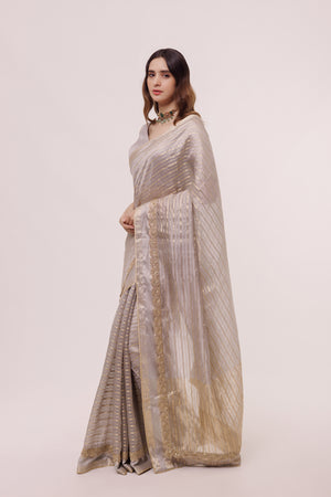 Shop a grey organza saree with embellishments and half sleeves blouse. Make a fashion statement on festive occasions and weddings with designer sarees, designer suits, Indian dresses, Anarkali suits, palazzo suits, designer gowns, sharara suits, and embroidered sarees from Pure Elegance Indian fashion store in the USA.