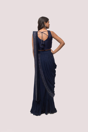 Shop the navy blue ruffle saree with sleeveless blouse. Make a fashion statement on festive occasions and weddings with designer sarees, designer suits, Indian dresses, Anarkali suits, palazzo suits, designer gowns, sharara suits, and embroidered sarees from Pure Elegance Indian fashion store in the USA.