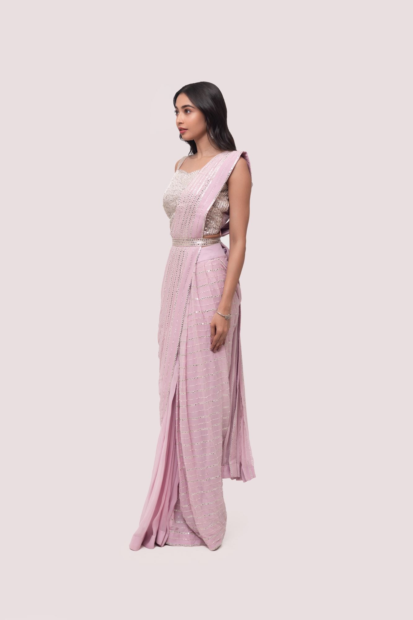 Shop the pink mirror work saree with a sleeveless blouse. Make a fashion statement on festive occasions and weddings with designer sarees, designer suits, Indian dresses, Anarkali suits, palazzo suits, designer gowns, sharara suits, and embroidered sarees from Pure Elegance Indian fashion store in the USA.