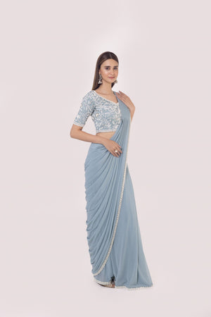 Shop a blue drape saree set embedded with moti work. Make a fashion statement on festive occasions and weddings with designer sarees, designer suits, Indian dresses, Anarkali suits, palazzo suits, designer gowns, sharara suits, and embroidered sarees from Pure Elegance Indian fashion store in the USA.