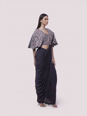 Shop grey net pre-stitched saree with flared blouse. Make a fashion statement on festive occasions and weddings with designer sarees, designer suits, Indian dresses, Anarkali suits, palazzo suits, designer gowns, sharara suits, and embroidered sarees from Pure Elegance Indian fashion store in the USA.