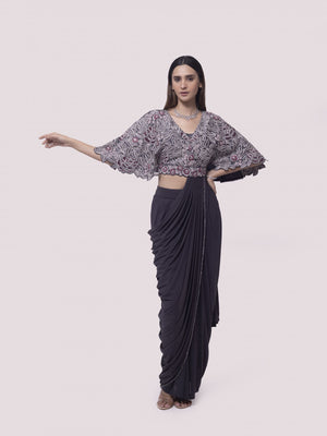 Shop grey net pre-stitched saree with flared blouse. Make a fashion statement on festive occasions and weddings with designer sarees, designer suits, Indian dresses, Anarkali suits, palazzo suits, designer gowns, sharara suits, and embroidered sarees from Pure Elegance Indian fashion store in the USA.