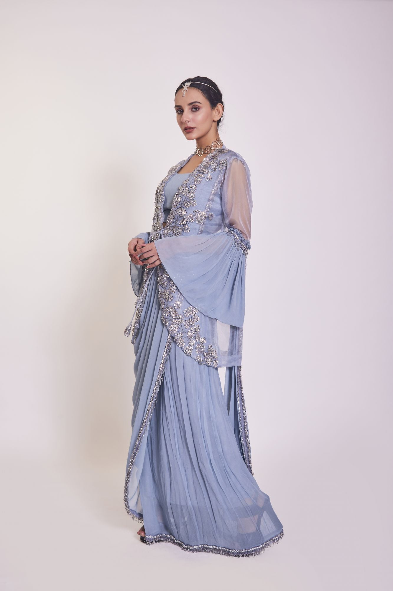 Shop blue georgette saree with ruffled sleeves cape. Make a fashion statement on festive occasions and weddings with designer sarees, designer suits, Indian dresses, Anarkali suits, palazzo suits, designer gowns, sharara suits, and embroidered sarees from Pure Elegance Indian fashion store in the USA.