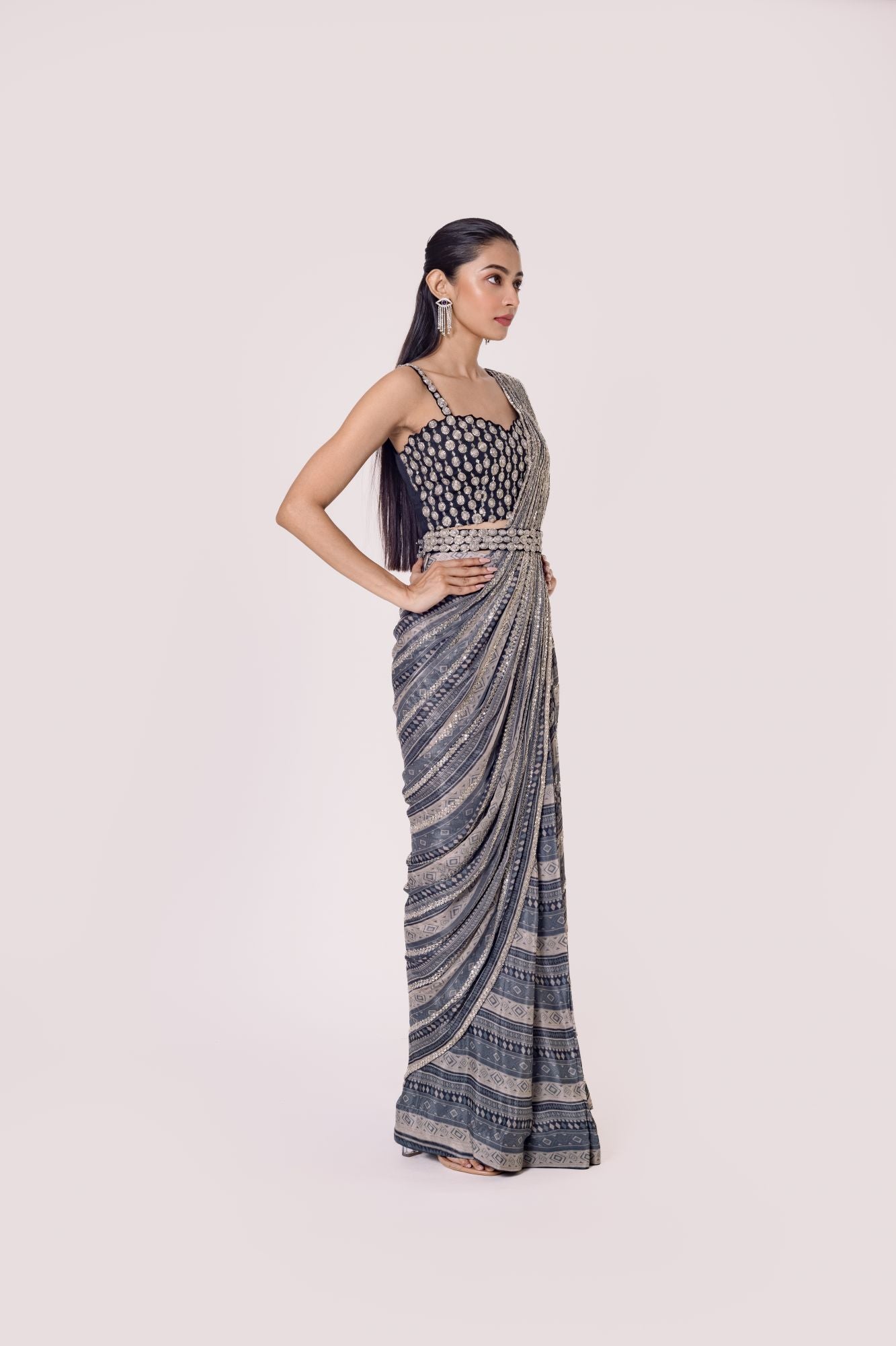Shop grey Black printed chiffon saree set featuring a strappy blouse and belt. Make a fashion statement on festive occasions and weddings with designer sarees, designer suits, Indian dresses, Anarkali suits, palazzo suits, designer gowns, sharara suits, and embroidered sarees from Pure Elegance Indian fashion store in the USA.