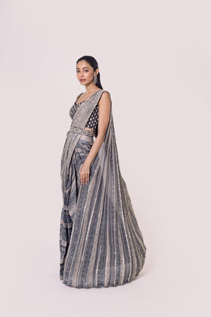 Shop grey Black printed chiffon saree set featuring a strappy blouse and belt. Make a fashion statement on festive occasions and weddings with designer sarees, designer suits, Indian dresses, Anarkali suits, palazzo suits, designer gowns, sharara suits, and embroidered sarees from Pure Elegance Indian fashion store in the USA.