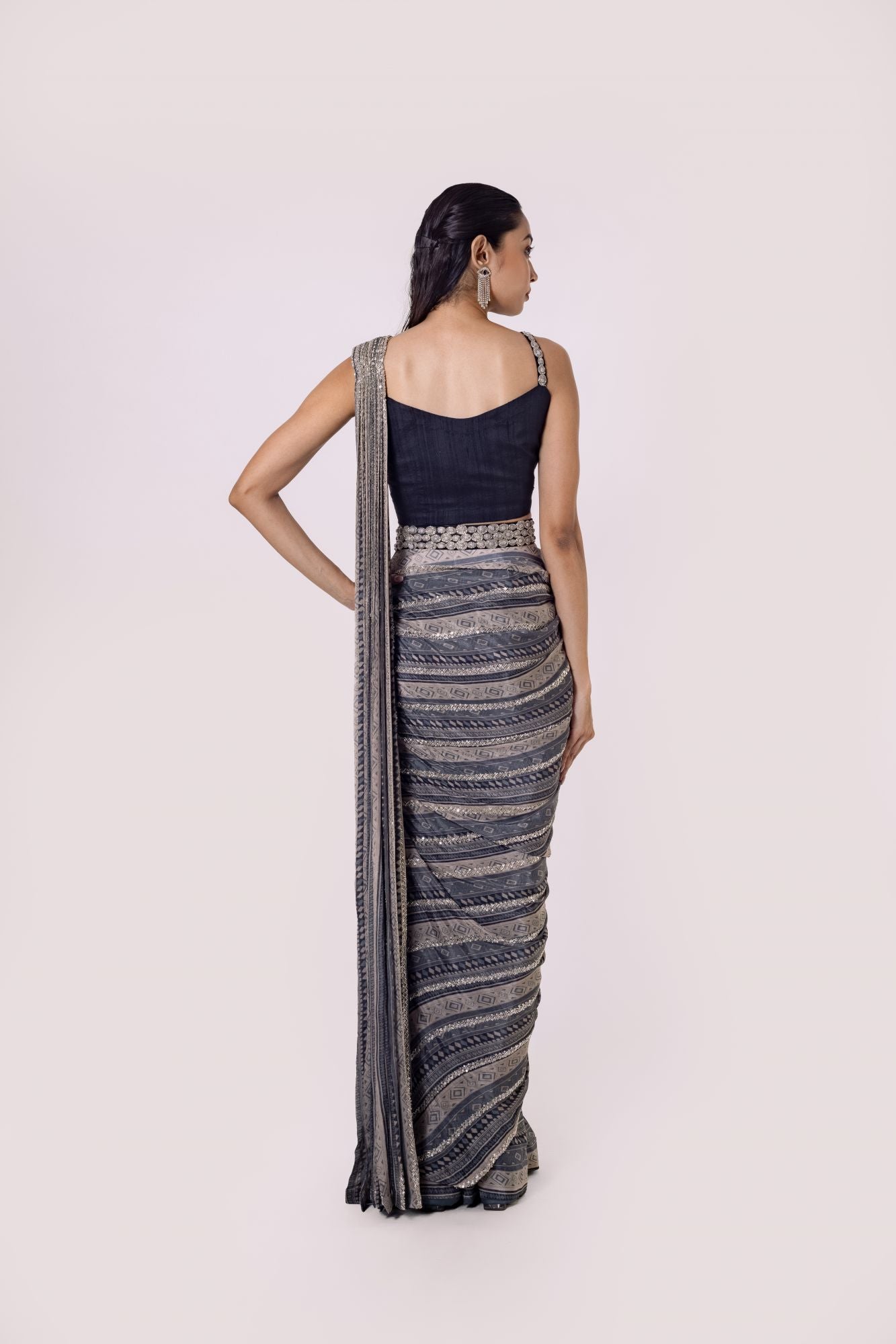 Shop grey Black printed chiffon saree set featuring a strappy blouse and belt. Make a fashion statement on festive occasions and weddings with designer sarees, designer suits, Indian dresses, Anarkali suits, palazzo suits, designer gowns, sharara suits, and embroidered sarees from Pure Elegance Indian fashion store in the USA.