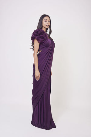 Shop wine satin drape dress with a designer blouse and floral design on the shoulder of the blouse. Make a fashion statement on festive occasions and weddings with designer sarees, designer suits, Indian dresses, Anarkali suits, palazzo suits, designer gowns, sharara suits, and embroidered sarees from Pure Elegance Indian fashion store in the USA.