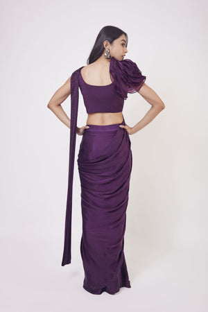 Shop wine satin drape dress with a designer blouse and floral design on the shoulder of the blouse. Make a fashion statement on festive occasions and weddings with designer sarees, designer suits, Indian dresses, Anarkali suits, palazzo suits, designer gowns, sharara suits, and embroidered sarees from Pure Elegance Indian fashion store in the USA.