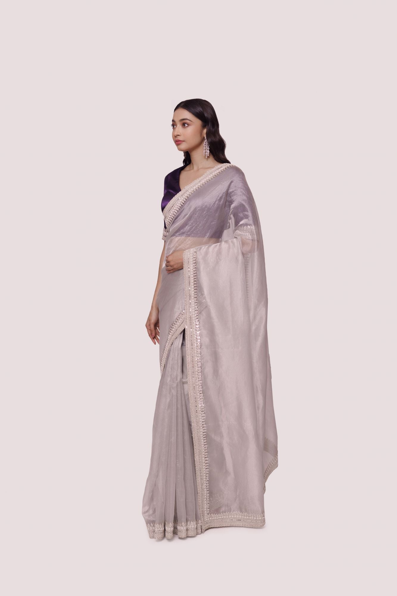 Shop grey saree with Indian embroidered contrasting purple blouse. Make a fashion statement on festive occasions and weddings with designer sarees, designer suits, Indian dresses, Anarkali suits, palazzo suits, designer gowns, sharara suits, and embroidered sarees from Pure Elegance Indian fashion store in the USA.