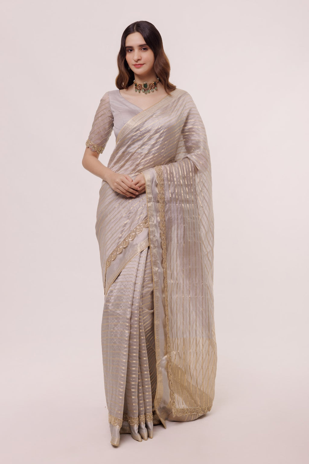 Shop a Grey handloom saree with stripes all over the body and embellished edges. It comes with a half sleeve grey blouse. Embellishments include cheed, tikki, and cutdana. Shop designer saris online in the USA from Pure Elegance.