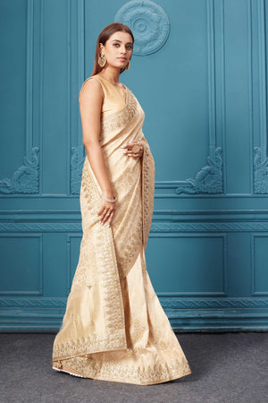 Shop cream Mashru Banarasi saree online in USA with embroidery. Look royal at weddings and festive occasions in exquisite designer sarees, handwoven sarees, pure silk saris, Banarasi sarees, Kanchipuram silk sarees from Pure Elegance Indian saree store in USA. -side