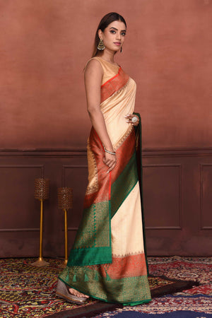 Buy cream tussar Banarasi saree online in USA with red green zari border. Look your best on festive occasions in latest designer sarees, pure silk sarees, Kanchipuram silk sarees, handwoven sarees, tussar silk sarees, embroidered sarees from Pure Elegance Indian clothing store in USA.-side