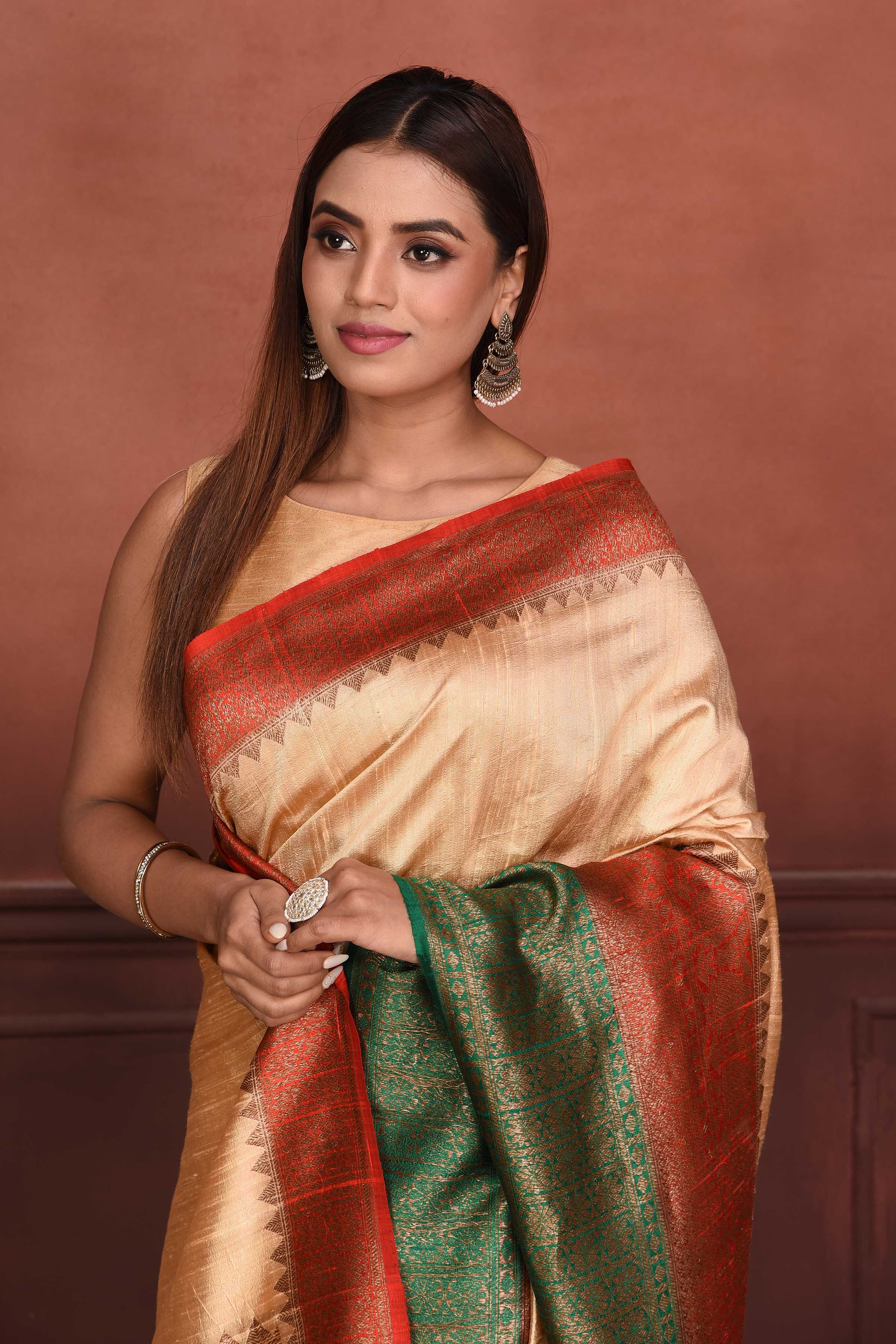 Buy cream tussar Banarasi saree online in USA with red green zari border. Look your best on festive occasions in latest designer sarees, pure silk sarees, Kanchipuram silk sarees, handwoven sarees, tussar silk sarees, embroidered sarees from Pure Elegance Indian clothing store in USA.-closeup