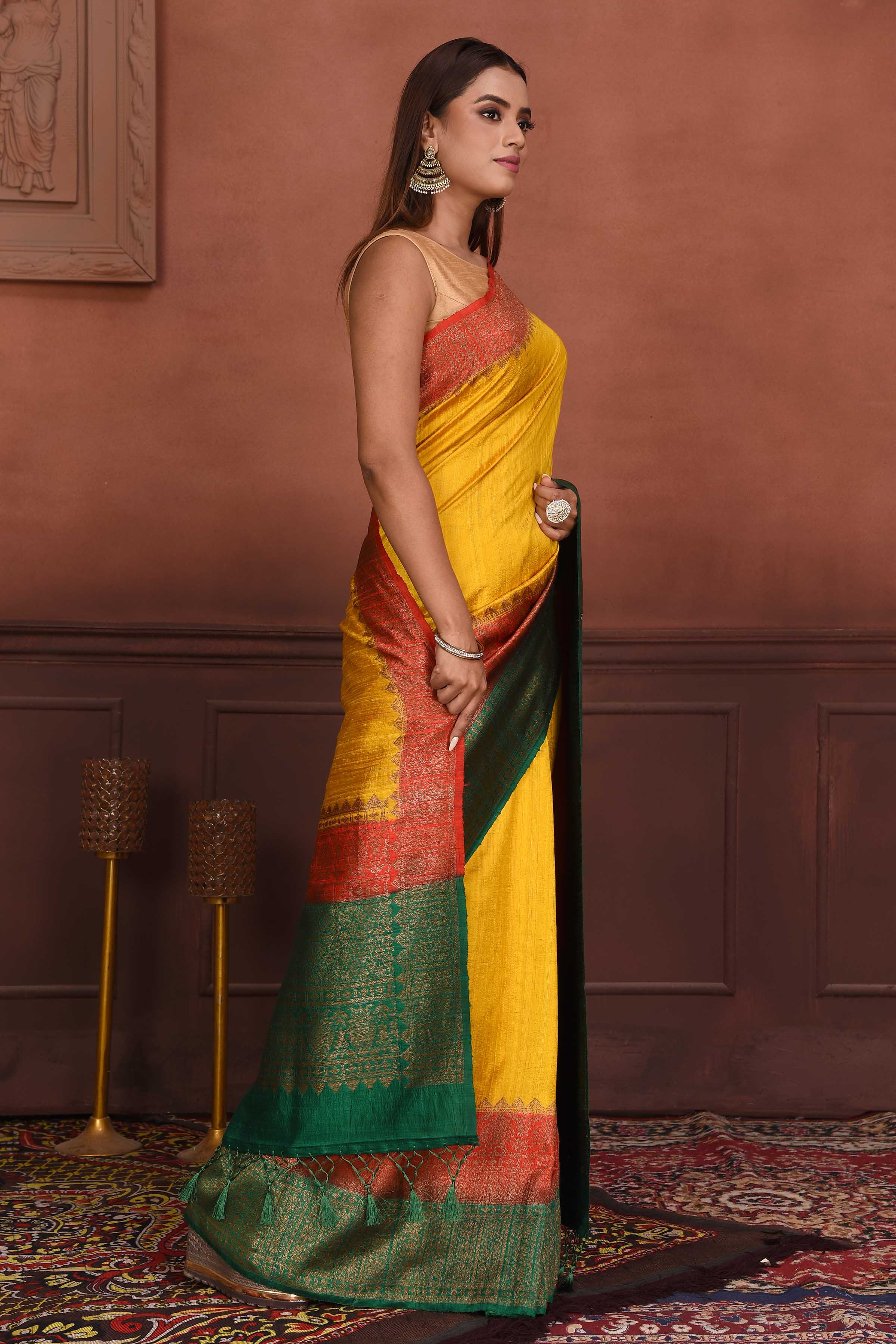 Shop yellow tussar Banarasi saree online in USA with red green zari border. Look your best on festive occasions in latest designer sarees, pure silk sarees, Kanchipuram silk sarees, handwoven sarees, tussar silk sarees, embroidered sarees from Pure Elegance Indian clothing store in USA.-side